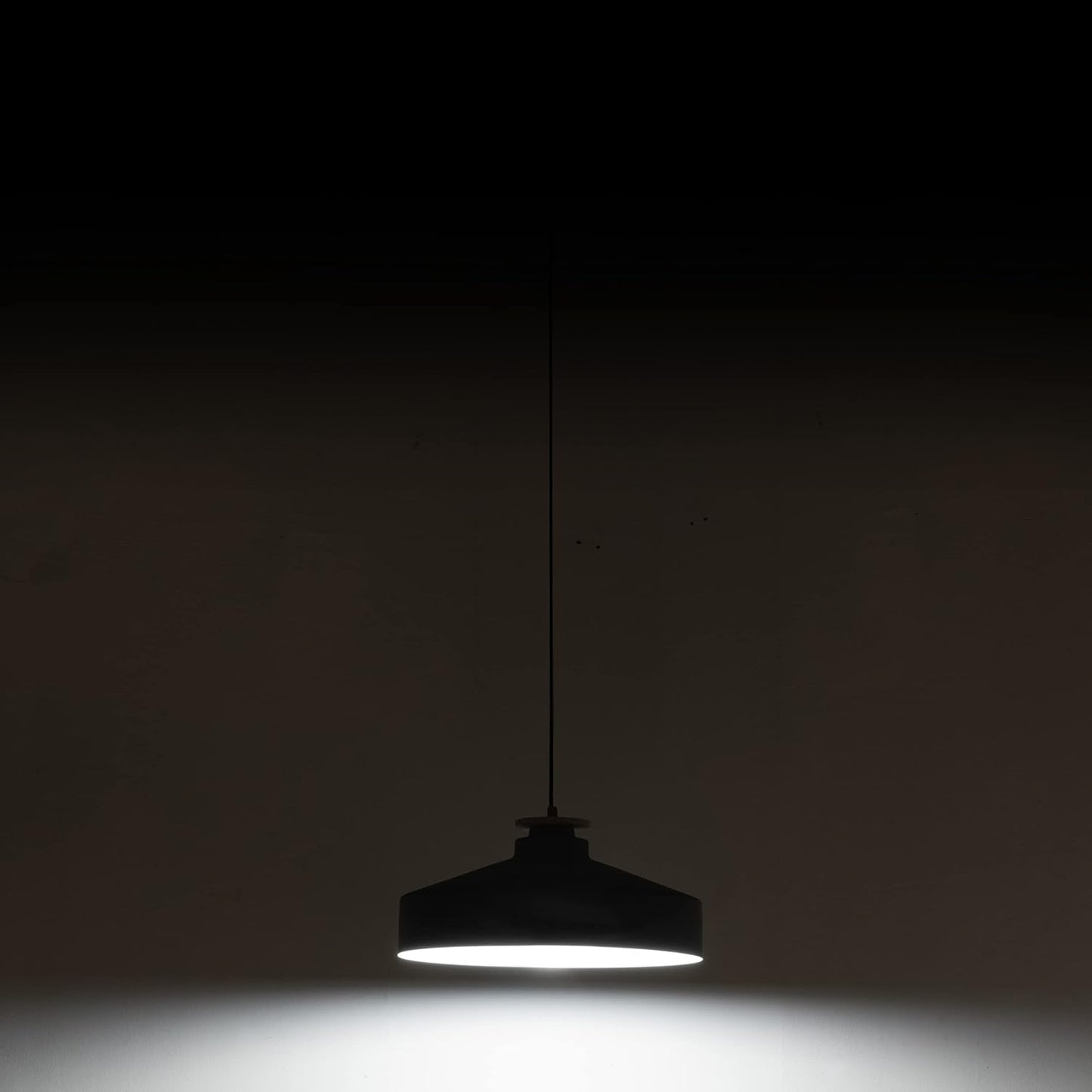 Black pendant light against a dark background