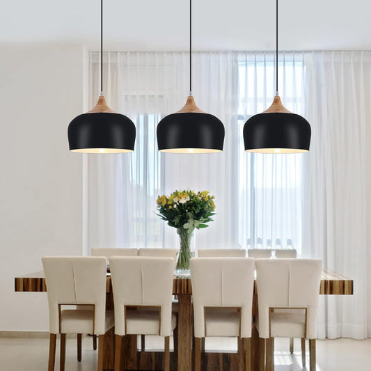 Modern dining room with black pendant lights, wooden table, and beige chairs.