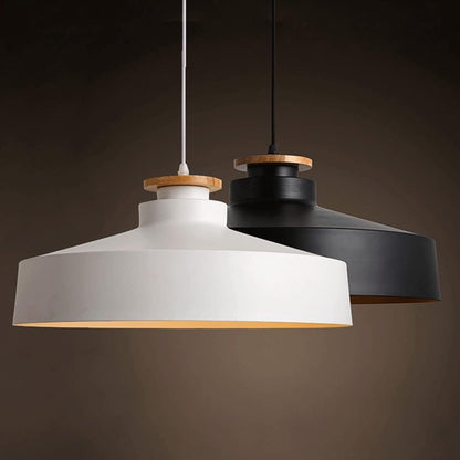 Two pendant lights, one white and one black, hanging against a dark background.