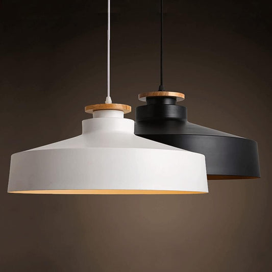 Two pendant lights, one white and one black, hanging against a dark background.